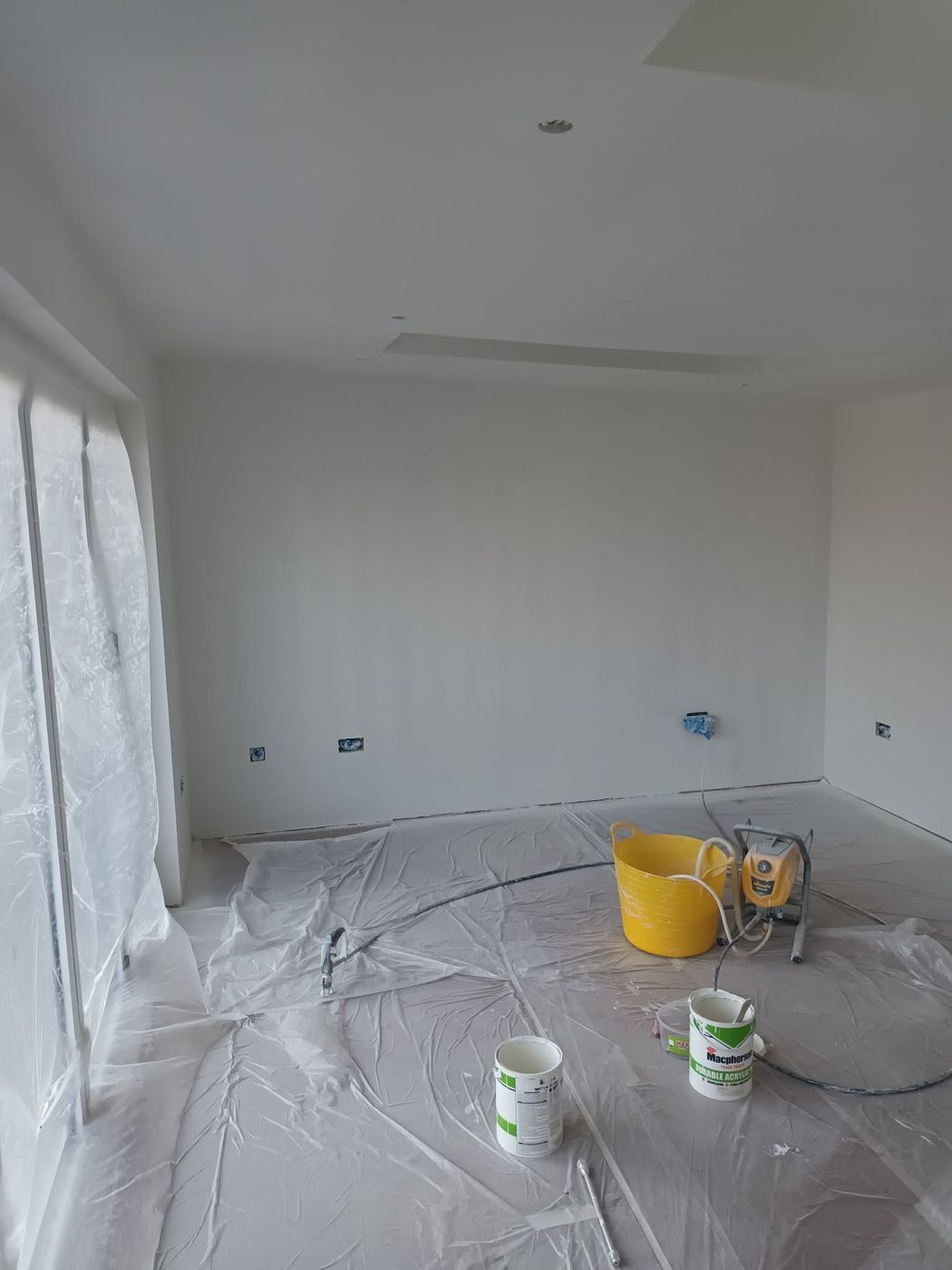 Freshly sprayed interior walls with spray equipment onsite