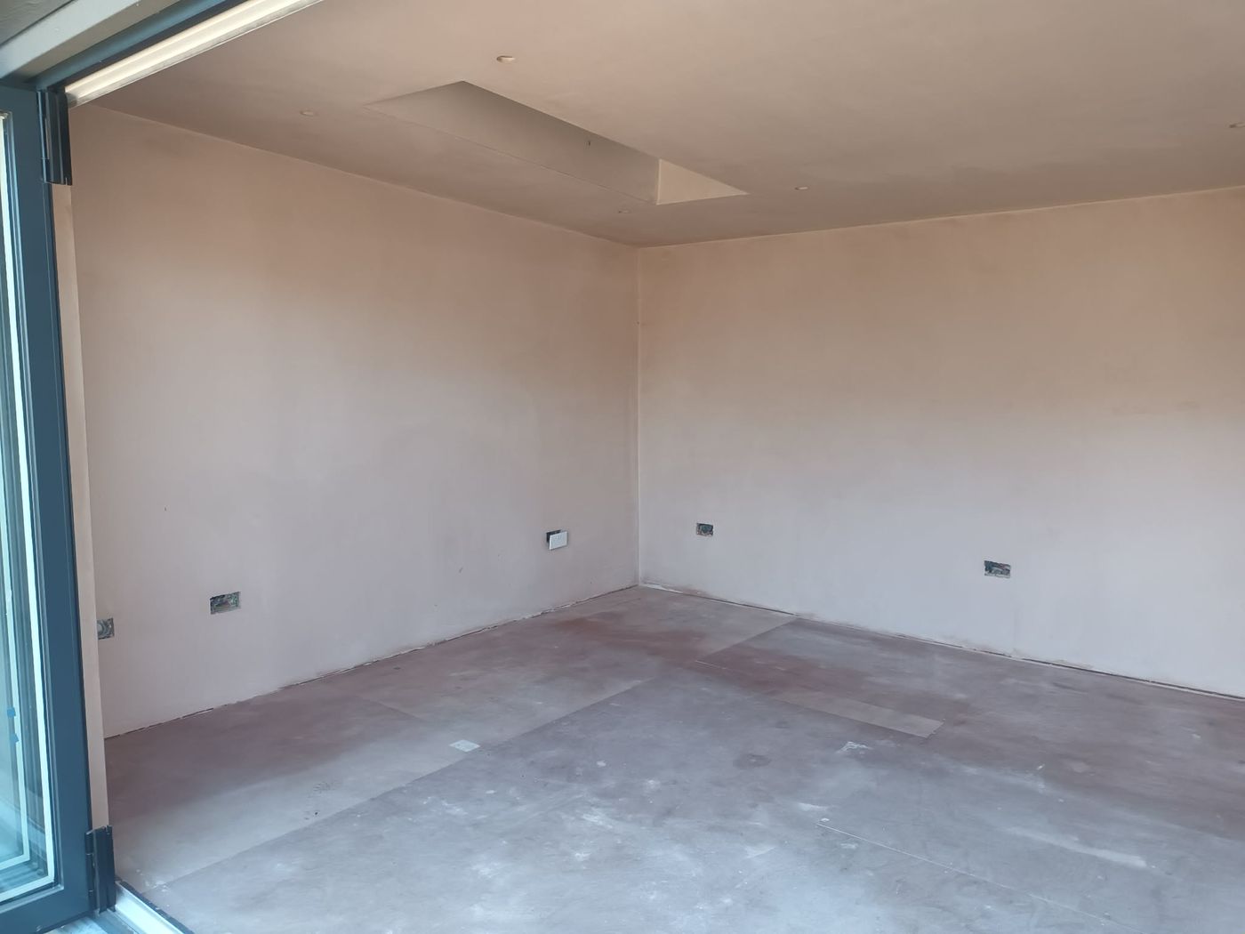 Bare plastered interior walls before spraying, bifold doors